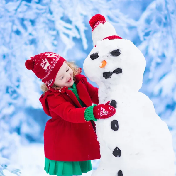 小女孩在冬天堆雪人 — 图库照片