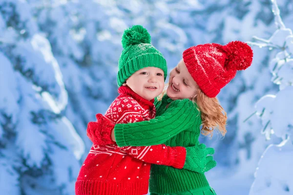 Kinderen spelen in snowy winter forest — Stockfoto