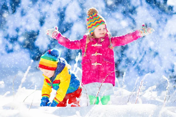 Barn har roligt i snöiga vinter park — Stockfoto