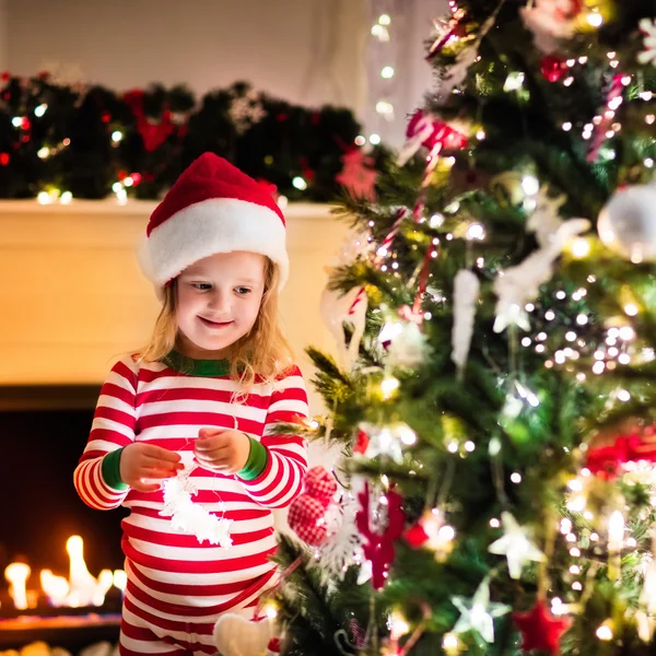 Crianças de pijama debaixo da árvore de Natal — Fotografia de Stock