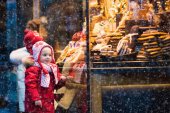 Kinder schauen sich auf Weihnachtsmarkt Süßigkeiten und Gebäck an