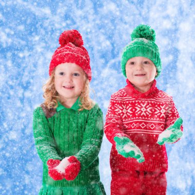 Karlı kış ormanda oynayan çocuklar