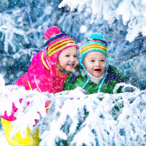Barn som leker i snöig skog — Stockfoto
