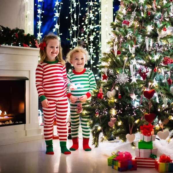 Çocuklar Noel ağacının altında pijama — Stok fotoğraf