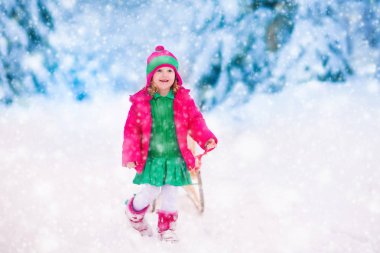 Karlı kış ormanda oynarken küçük kız