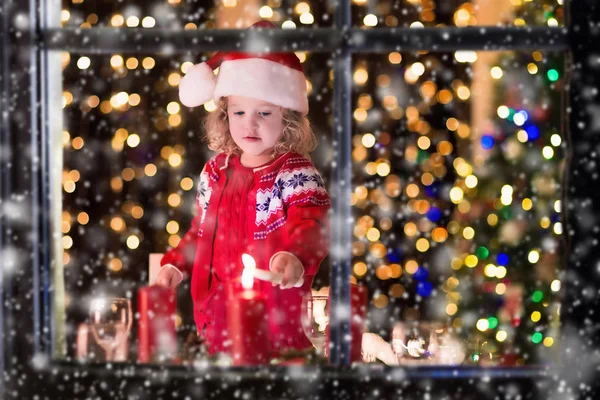 Little girl lighting candles at Christmas dinner — Stock Photo, Image