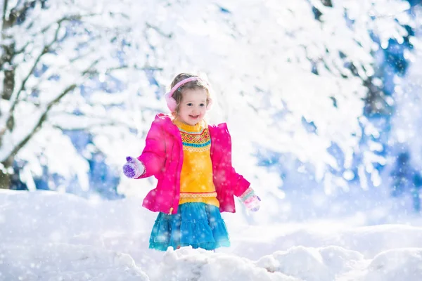Παιδί που παίζει στο χιονισμένο χειμώνα πάρκο — Φωτογραφία Αρχείου