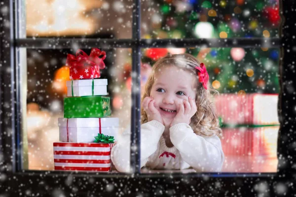 Dítě sleduje z okna na Štědrý den — Stock fotografie