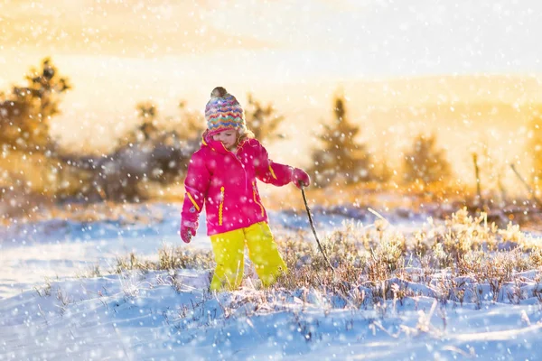Ребенок веселится в снежном зимнем парке — стоковое фото
