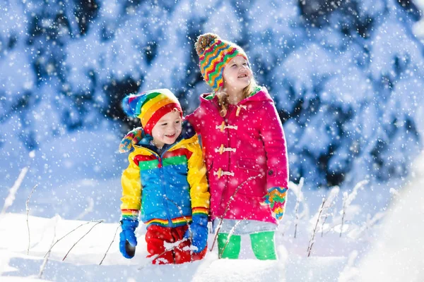 Παιδιά που παίζουν στο χιονισμένο χειμώνα πάρκο — Φωτογραφία Αρχείου