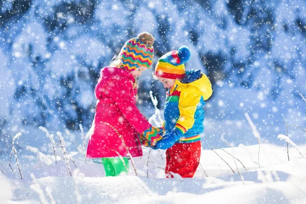 Παιδιά που παίζουν στο χιονισμένο χειμώνα πάρκο — Φωτογραφία Αρχείου