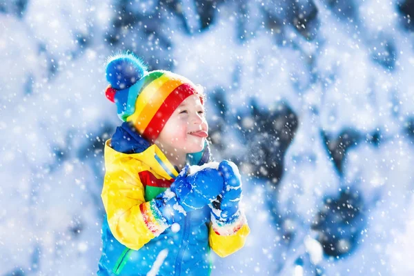 Kind vangen van sneeuw in de winter park — Stockfoto