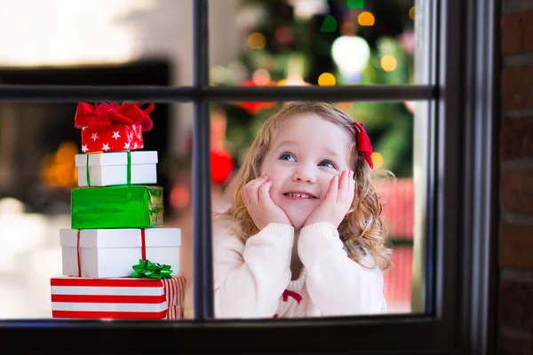 Barn titta ut ur fönstret på julafton — Stockfoto