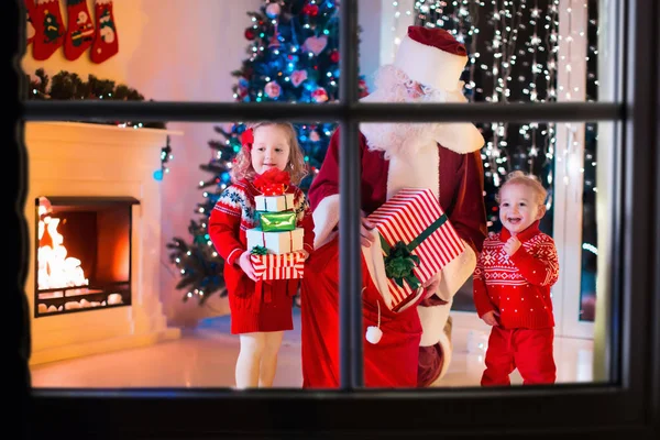 Crianças e Santa abrindo presentes de Natal — Fotografia de Stock