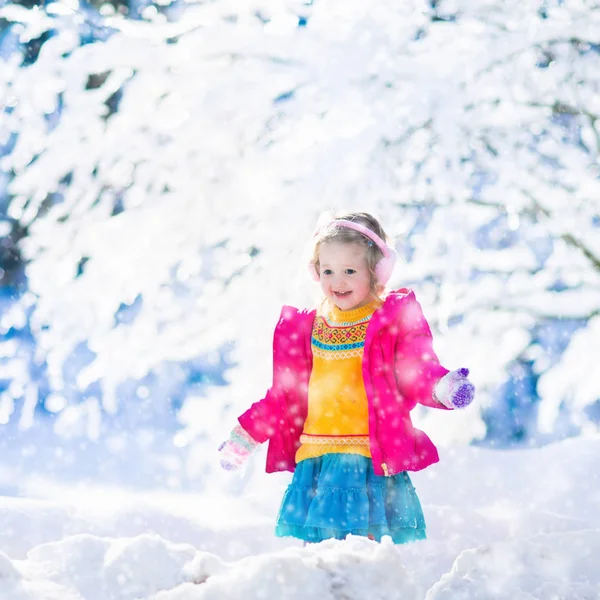 Enfant jouant dans un parc d'hiver enneigé — Photo