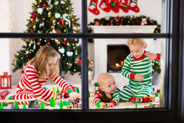 Kids playing with toy railroad on Christmas morning — Stock Photo, Image