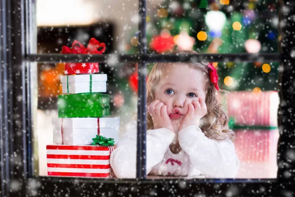 Bambino che guarda fuori dalla finestra la vigilia di Natale — Foto Stock