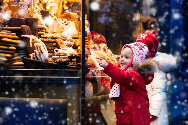 Kinder schauen sich auf Weihnachtsmarkt Süßigkeiten und Gebäck an — Stockfoto