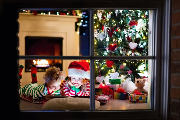 Niños en pijama bajo el árbol de Navidad — Foto de Stock