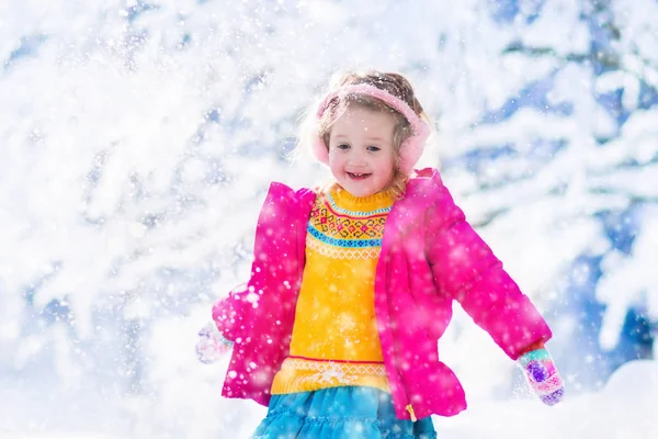 Niña jugando a las bolas de nieve en el parque de invierno —  Fotos de Stock