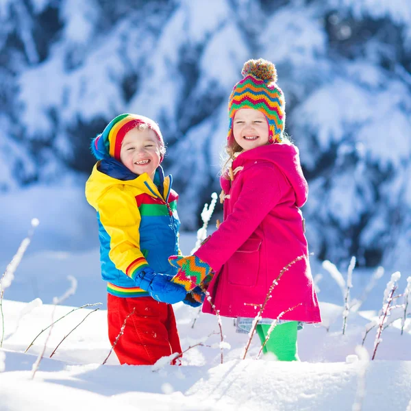 Дети играют в снежном зимнем парке — стоковое фото