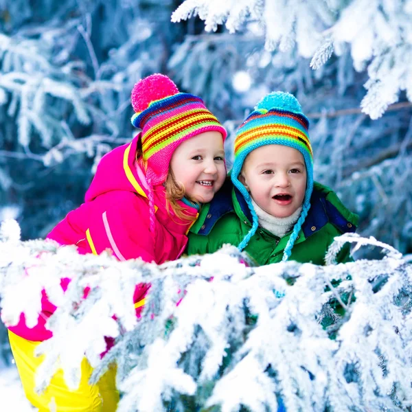 Barn som leker i snöig skog — Stockfoto