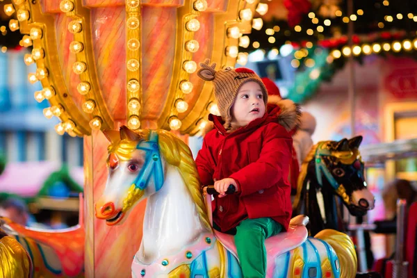 Child riding carousel on Christmas market — Stock Photo, Image