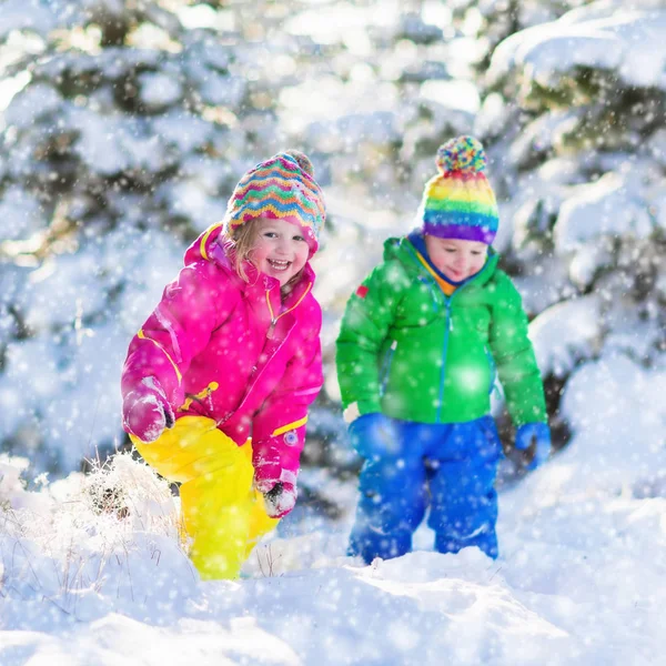 Дети играют в снежном зимнем парке — стоковое фото