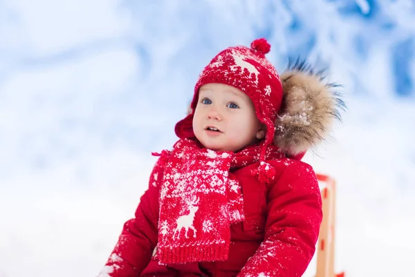 Los niños juegan en la nieve. Paseo en trineo de invierno para niños —  Fotos de Stock