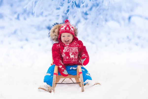 Děti hrají ve sněhu. Jízda na saních zimní pro děti — Stock fotografie