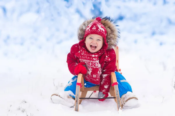 As crianças brincam na neve. Passeio de trenó de inverno para crianças — Fotografia de Stock