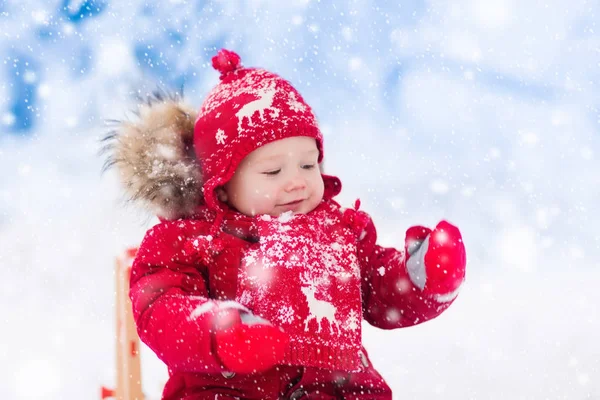 Los niños juegan en la nieve. Paseo en trineo de invierno para niños —  Fotos de Stock