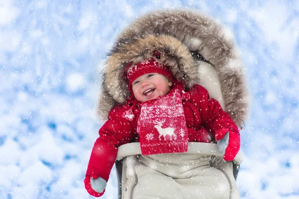 Bebê em carrinho no parque de inverno com neve — Fotografia de Stock