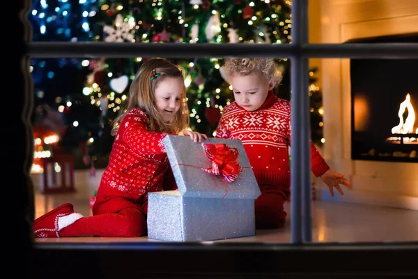 孩子们打开圣诞礼物在壁炉 — 图库照片