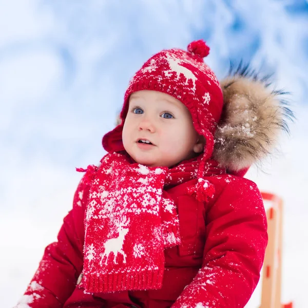 Los niños juegan en la nieve. Paseo en trineo de invierno para niños —  Fotos de Stock