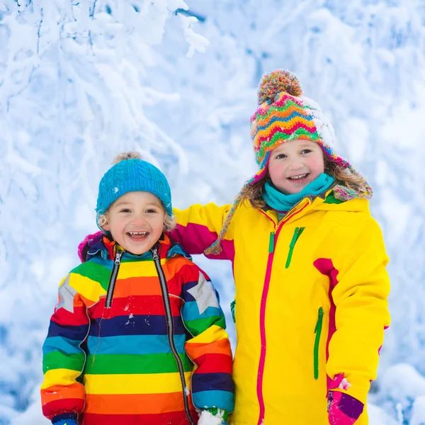 Дети играют со снегом в зимнем парке — стоковое фото
