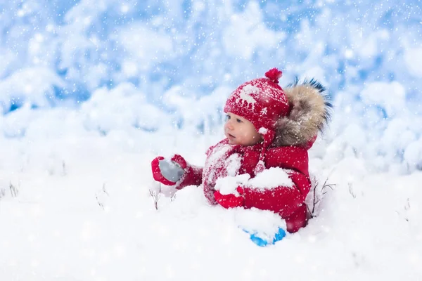 Barnet leker med snö på vintern. — Stockfoto