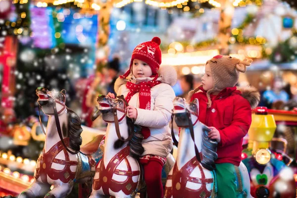 Children riding carousel on Christmas market — Stock Photo, Image