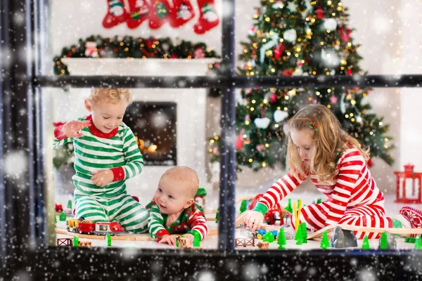 Dzieci bawiące się z kolei zabawka na Boże Narodzenie rano — Zdjęcie stockowe