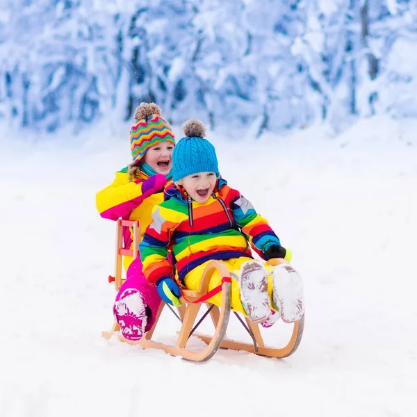 Kinderen spelen in de sneeuw. Winter sleigh ride voor kinderen — Stockfoto