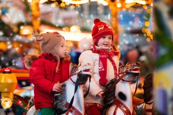 Children riding carousel on Christmas market — Stock Photo, Image