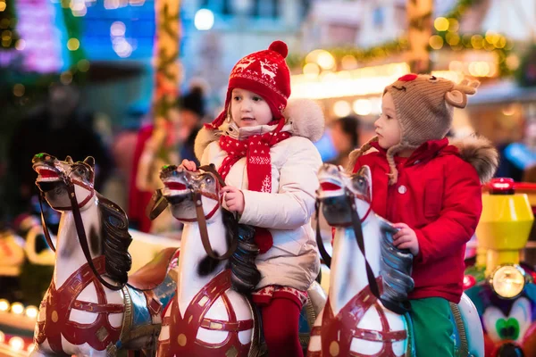 Niños montando carrusel en el mercado de Navidad — Foto de Stock