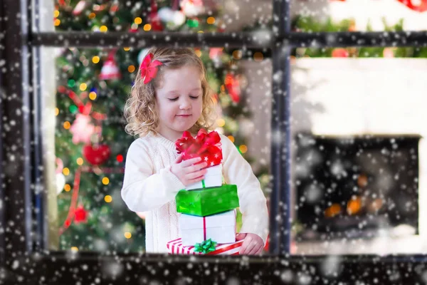 開く少女は、クリスマスの朝にプレゼントします。 — ストック写真