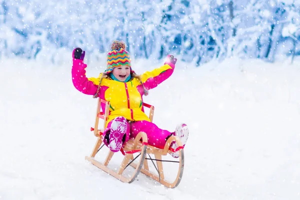 Los niños juegan en la nieve. Paseo en trineo de invierno para niños — Foto de Stock