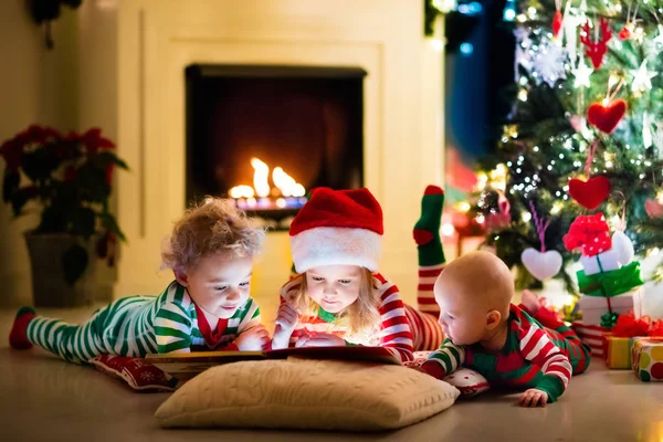 Anak-anak dengan piyama di bawah pohon Natal — Stok Foto