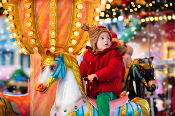 Child riding carousel on Christmas market — Stock Photo, Image