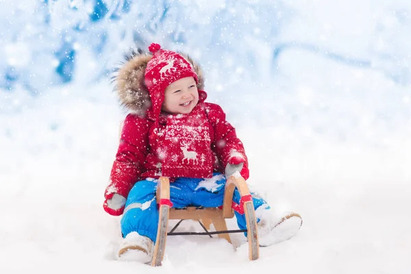 Діти грають у снігу. Зимові санки для дітей — стокове фото