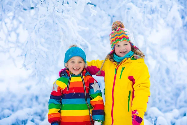 Barnen leker med snö i vinter park — Stockfoto