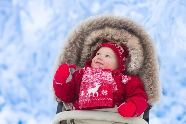 Bebé en cochecito en el parque de invierno con nieve — Foto de Stock