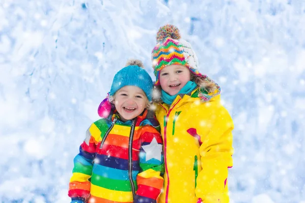 Barnen leker med snö i vinter park — Stockfoto